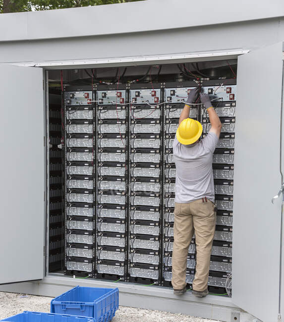 Engineer connecting energy storage batteries for back up power to an electric power plant — Stock Photo