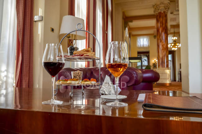 Weingläser und Vorspeisen auf einem Tisch in einer Luxussuite; Varese, Lombardei, Italien — Stockfoto