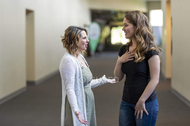 Молода жінка та її молодіжний керівник обговорюють свою віру в коридорі церкви: Едмонтон, Альберта, Канада. — стокове фото