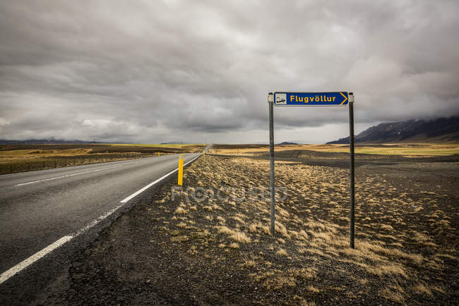 Paysage routier et de toundra avec panneau routier indiquant l'aéroport ; Islande — Photo de stock