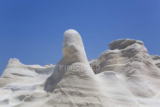 Sand formations against a blue sky, Sarakiniko Beach; Milos Island, Cyclades, Greece — Fotografia de Stock