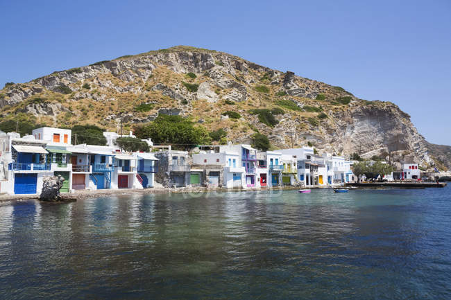 Klima village with white houses and colourful accents along the water edge; Klima, Milos Island, Cyclades, Greece — Stock Photo
