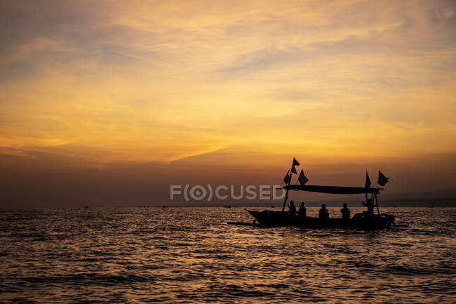 Indonesian jukung, traditional wooden outrigger canoe at sunrise; Lalang, Bali, Indonesia — Stock Photo