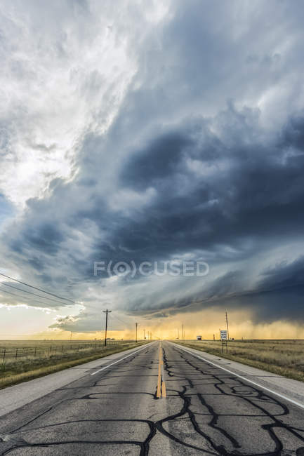 Supercellule à faible précipitation traversant une autoroute vide près de Roswell, Nouveau-Mexique ; Rowell, Nouveau-Mexique, États-Unis d'Amérique — Photo de stock