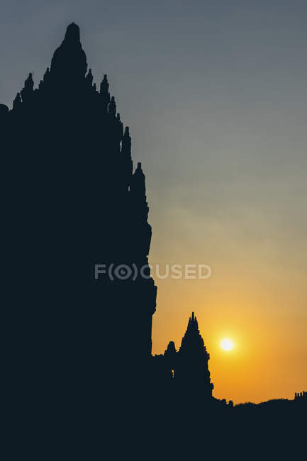 Coucher de soleil au temple Prambanan avec des sommets silhouettés ; Yogyakarta, Indonésie — Photo de stock
