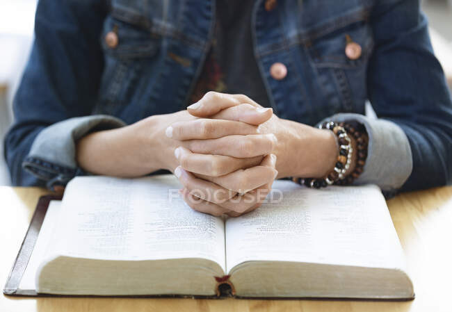 A mature woman praying, after doing some personal Bible study, in a coffee shop : Edmonton, Alberta, Canada — Stock Photo