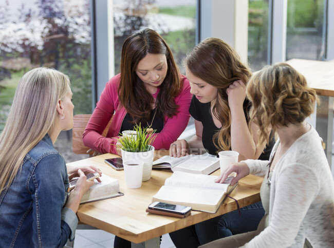 Un grupo de mujeres se reunieron para un estudio bíblico en una cafetería en una iglesia; Edmonton, Alberta, Canadá - foto de stock