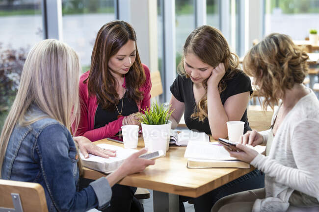 Un grupo de mujeres se reunieron para un estudio bíblico en una cafetería en una iglesia; Edmonton, Alberta, Canadá - foto de stock