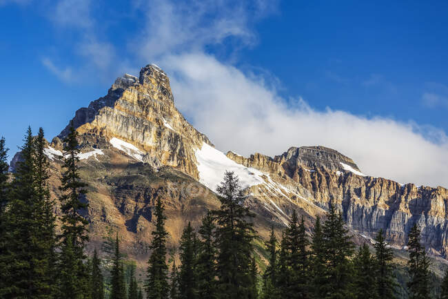 Montagna picco scogliera drammaticamente illuminato dal sole con cielo blu e nuvole, Yoho National Park; Campo, Columbia Britannica, Canada — Foto stock