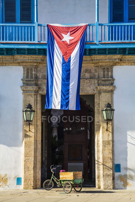 Bandeira nacional de Cuba pendurada sobre a entrada do Palácio dos Artesãos (Palácio de la Artesania), Cidade Velha; Havana, Cuba — Fotografia de Stock