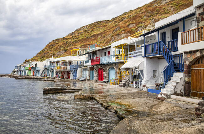 Barandillas pintadas de colores y puertas de casas a lo largo del paseo marítimo; Milos, Grecia - foto de stock