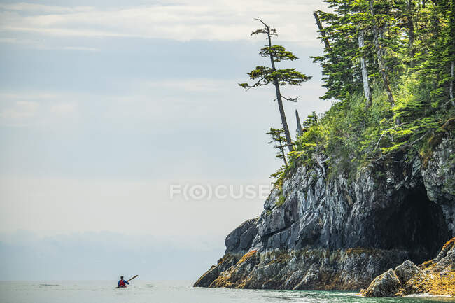 Kayaker pagaie à travers les eaux calmes dans les magnifiques paysages du détroit du Prince William ; Alaska, États-Unis d'Amérique — Photo de stock