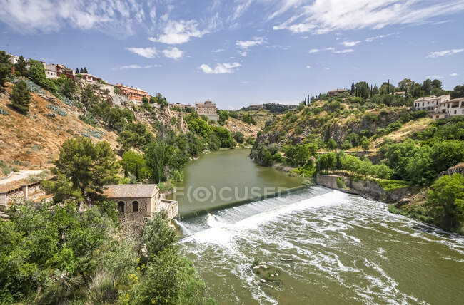 Río Tajo que fluye a través de la Ciudad Imperial de Toledo, Patrimonio de la Humanidad de la Unesco; Toledo, España - foto de stock