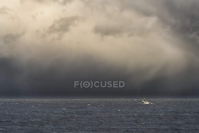Ciel orageux au-dessus de l'océan et un bateau en eau libre au large des côtes du Bouclier Sud ; Tyne and Wear, Angleterre — Photo de stock