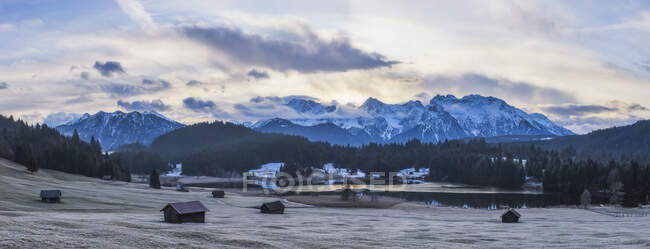 Paesaggio invernale bavarese con baite, lago e montagne alpine innevate, punto panoramico; Geroldsee, Baviera, Germania — Foto stock