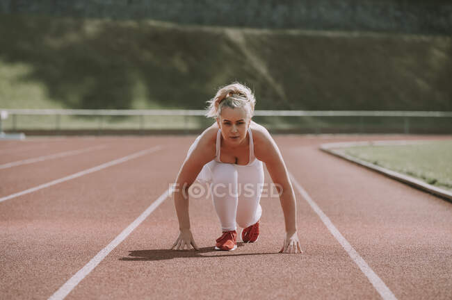 Femme en position de départ pour courir sur une piste ; Wellington, Nouvelle-Zélande — Photo de stock