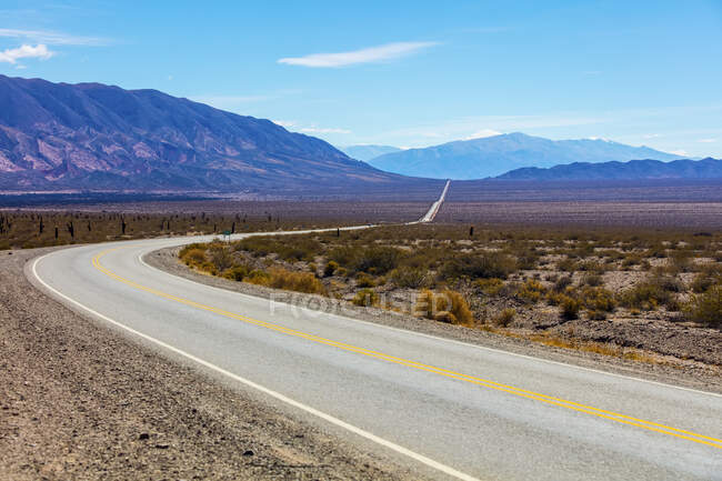 Estrada passando pela paisagem árida e montanhosa do Parque Nacional Los Cardones; Província de Salta, Argentina — Fotografia de Stock