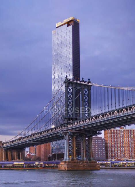 Строящийся небоскреб с Манхэттенским мостом через Ист-Ривер на переднем плане, Манхэттен; Нью-Йорк, Нью-Йорк, США — стоковое фото