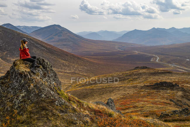 Mulher explorando as montanhas ao longo da estrada Dempster durante o outono no outono; Yukon, Canadá — Fotografia de Stock