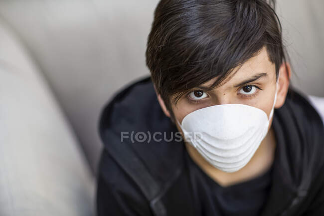 Pre-teen boy wearing a protective mask to protect against COVID-19 during the Coronavirus World Pandemic; Toronto, Ontario, Canada — Stock Photo