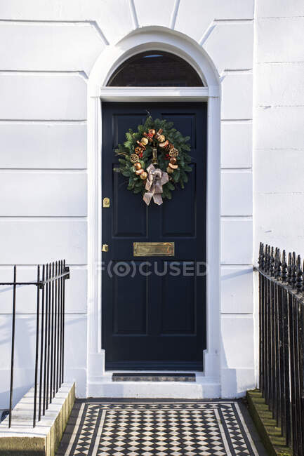Una corona di Natale decorativa su una porta di casa blu scuro; Londra, Inghilterra — Foto stock