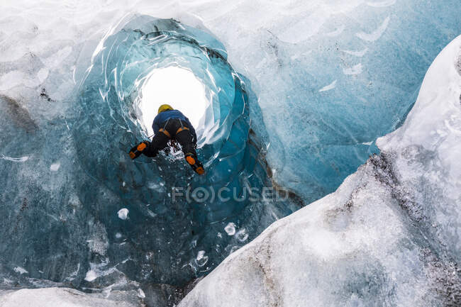 Homme explorant une grotte de glace ; Côte Sud, Islande — Photo de stock