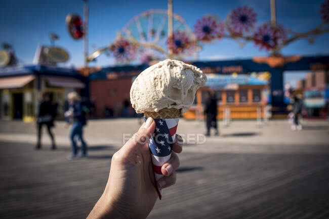 Cropped shot of hand holding an ice cream cone; Coney Island, Brooklyn, New York, United States of America — Stock Photo