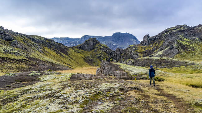 Uma mulher caminhando no terreno acidentado do sul da Islândia; Grimsnes- og Grafningshreppur, região sul, Islândia — Fotografia de Stock