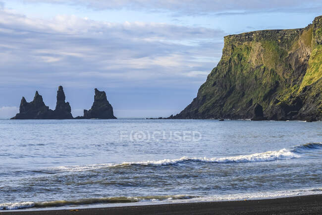 Cime di cumuli marini e scogliere frastagliate lungo la costa dell'Islanda meridionale; Regione meridionale, Islanda — Foto stock