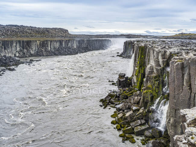 Penhascos rochosos rochosos ao longo de Jokulsa um rio Fjollum na cachoeira Dettifoss; Skutustadahreppur, Região Nordeste, Islândia — Fotografia de Stock