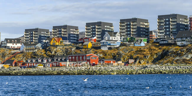 Casas coloridas a lo largo de la costa rocosa de Nuuk; Nuuk, Sermersooq, Groenlandia - foto de stock