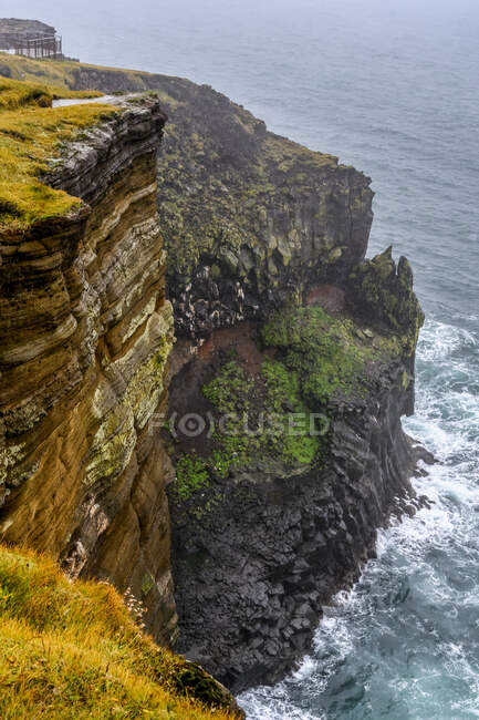 Rugged cliffs along the coast in mist, Snaefellsjokull National Park; Helgafellssveit, Regione occidentale, Islanda — Foto stock