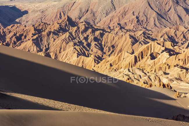 Enormes dunas de arena al atardecer con montañas desérticas al fondo; San Pedro de Atacama, Atacama, Chile - foto de stock