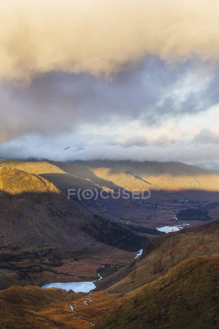 Dramatic sunset with low clouds over the lakes in the Black Valley; County Kerry, Ireland — Stock Photo