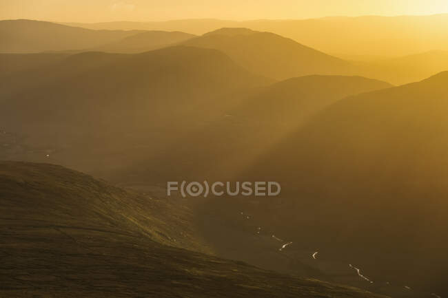 Morning sun rays over the Gearsallagh Valley and the Owenreagh River, MacGillycuddy's Reeks; County Kerry, Ireland — Stock Photo