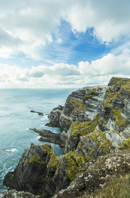 The steep, rugged cliffs on a sunny cloudy day in summer; County Kerry, Ireland — Stock Photo