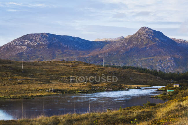 Landschaftsaufnahme eines Flusses in Connemara mit einem Teil der Twelve Bens Mountains im Hintergrund; Connemara, County Galway, Irland — Stockfoto