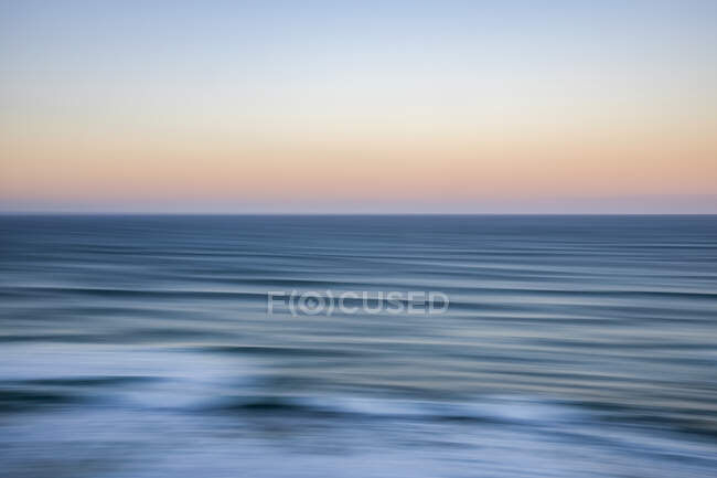 Panning sunrise over ocean, viewed from The Twelve Apostles, Port Campbell National Park; Port Campbell, Victoria, Australia — Stock Photo