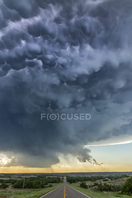 Einstürzendes schweres Gewitter, das vom Blitz angezündet wird, während es die Autobahn überquert; Durham, Oklahoma, Vereinigte Staaten von Amerika — Stockfoto