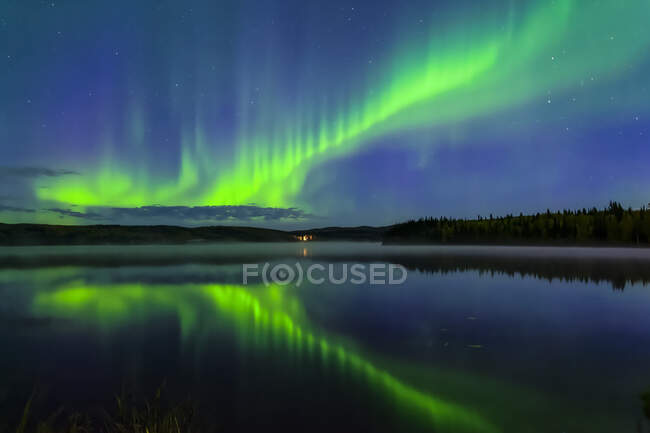 Aurora verde brillante bailando sobre el lago Birch con reflejos, Interior Alaska en otoño; Fairbanks, Alaska, Estados Unidos de América - foto de stock