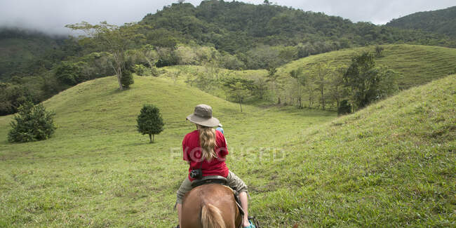 Девочка верхом на лошади по холмам; Сакапа, Гуатемала — стоковое фото