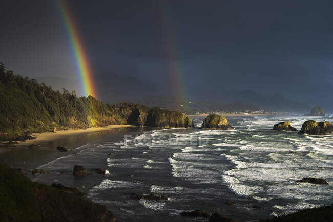 Arcobaleni visti attraverso nuvole di tempesta sulla spiaggia di mezzaluna; Cannon Beach, Oregon, Stati Uniti d'America — Foto stock