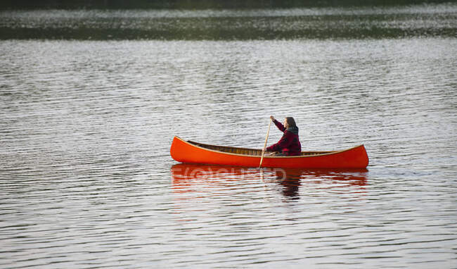 Chica en una canoa naranja; Ontario, Canadá - foto de stock
