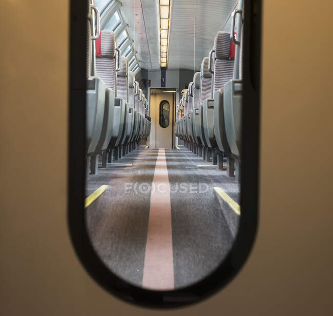 Vue des sièges dans un train par la fenêtre d'une porte ; Locarno, Tessin, Suisse — Photo de stock