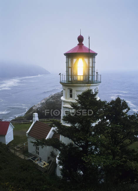 Der Leuchtturm von Heceta Head, der an einem nebligen Morgen blinkt; Florence, Oregon, Vereinigte Staaten von Amerika — Stockfoto