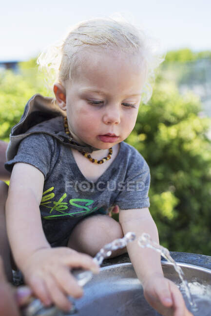 Young Boy At The Drinking Fountain On A Hot Summer Day; Toronto, Ontario, Canada — Photo de stock