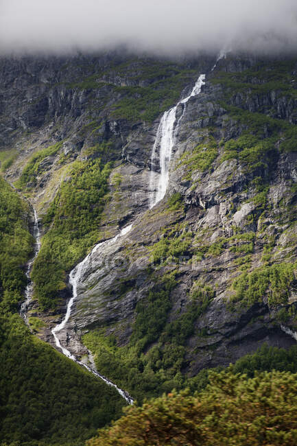 Un flusso che scende da una montagna con una nuvola densa; Andalsnes, Rauma, Norvegia — Foto stock