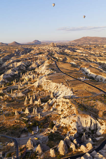 Mongolfiere in volo su un paesaggio accidentato; Cappadocia, Turchia — Foto stock