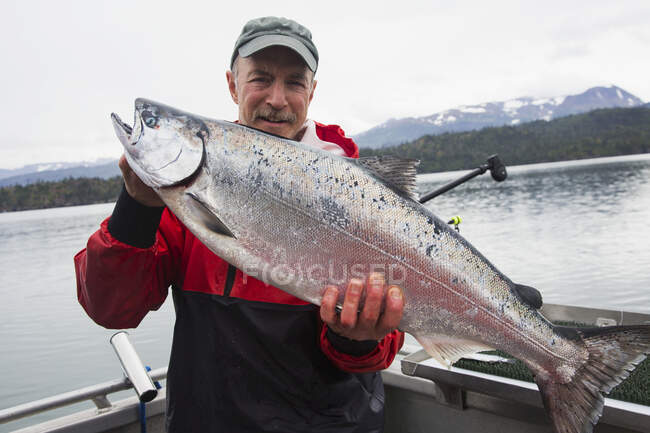 Mann fängt Königslachs in der Nähe von Homer Alaska in Kachemak Bay — Stockfoto