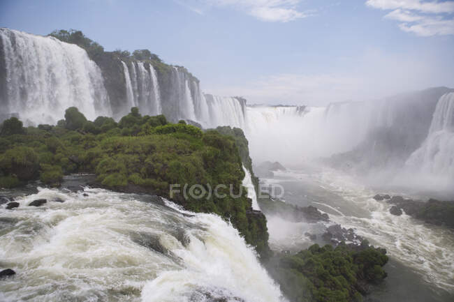 Водоспад Ігуаку у Бразилії на передньому плані та в Аргентині. — стокове фото